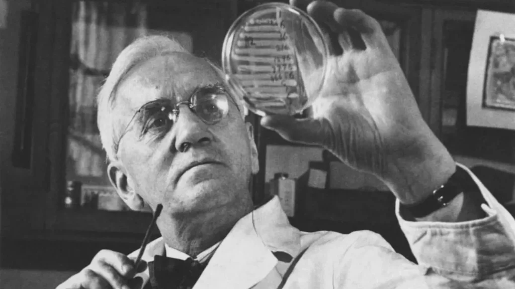 Alexander Fleming examinando una muestra en una placa de Petri